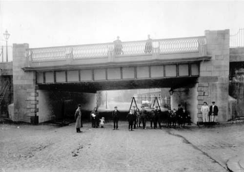A view looking on to the bridge over Bridge Street in June 1910. People pose for the camera.