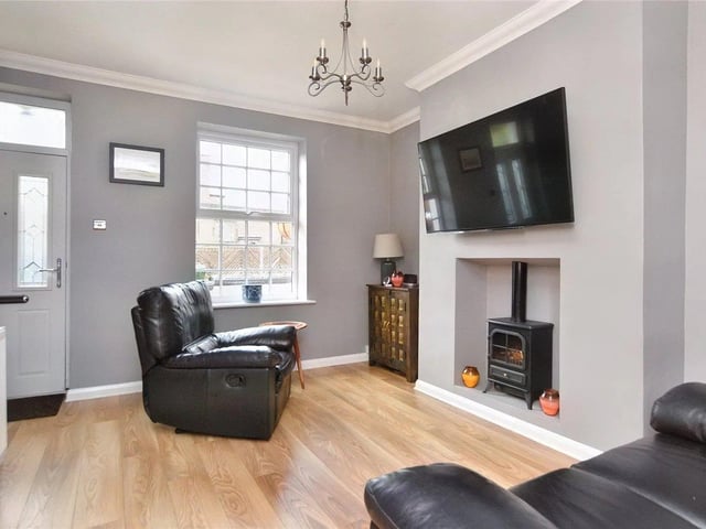 To the ground floor, a covered entrance door opens into a living room which has a staircase to the first floor.