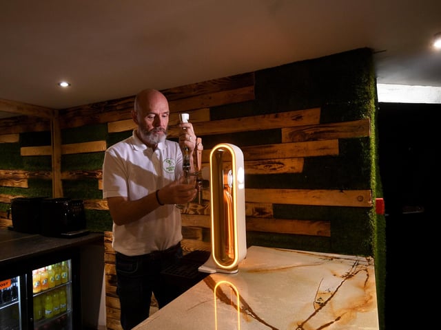 Mark Flanagan is pictured in the fully-licensed bar, where players can enjoy a drink with friends