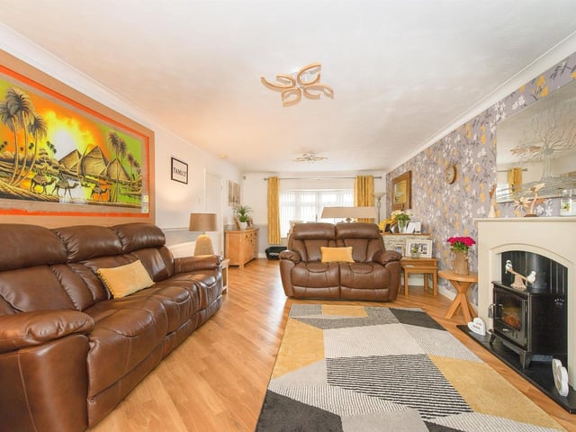 A feature fireplace with hearth houses an electric fire in the lounge with Karndean flooring, coving to the ceiling, and a double glazed, front bay window.