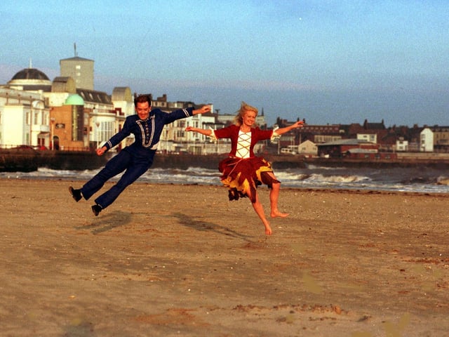 Cinderella (Shari Kay) takes time out from dress rehearsal at the Spa Theate for a romantic run along Bridlington South Beach with her panto hero Buttons (Paul Valentin) in December 1999.