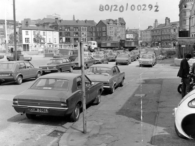 Looking north along Hunslet Lane, seen from Tetley's Brewery. Many cars are parked in the foreground. On the right, a man is looking at motorbikes on display outside Motor Cycle Spares, No.47 Hunslet Lane. Next to this is the junction with Salem Place, with Salem Congregational Church beyond. Further along are are offices of the British Waterways Board. On the left, bus shelters can be seen in front of the Red Lion public house. Pictured in August 1980.