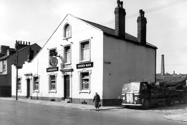 The Green Man pub, supplier of Ramsden's stone trough ales. The second window on the left has 'Public Bar' etched on the glass while the window in the centre says 'Outdoor Room'. On the far right a Ramsdens delivery lorry is parked in Vicar Street piled high with crates, while a woman stands in front ready to cross Dewsbury Road. In the distance can be seen the chimney of the Mineral Water works. This is one of two pubs named Green Man in Hunslet, the other being Green Man Inn at number 77 Church Street that was transformed from a pub to a cafe in the early 1950s. Both pubs have since been demolished and became the site of school playing fields. The Dewsbury Road pub is now used by Greenwood Primary School.