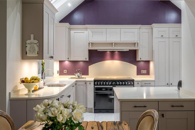 A bespoke fitted kitchen has quality appliances and is open plan to a dining area.