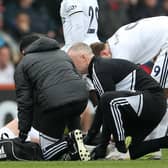 Leeds United's Scottish defender Liam Cooper is treated by medical staff  (Photo by STEVE BARDENS/AFP via Getty Images)