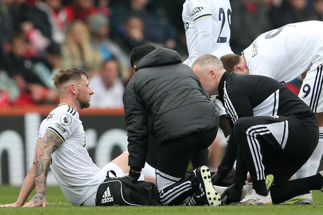 Leeds United's Scottish defender Liam Cooper is treated by medical staff (Photo by STEVE BARDENS/AFP via Getty Images)