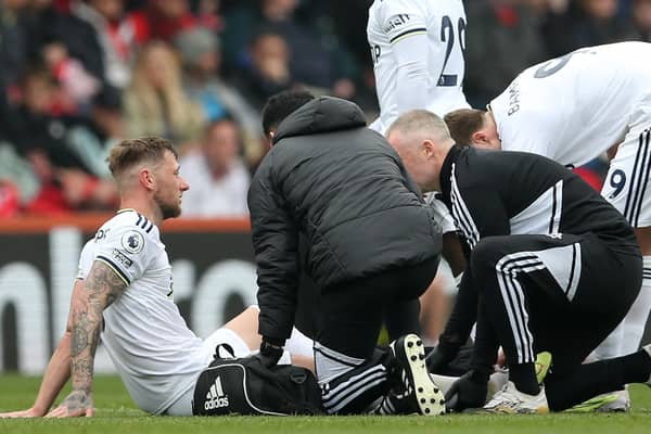 Leeds United's Scottish defender Liam Cooper is treated by medical staff  (Photo by STEVE BARDENS/AFP via Getty Images)