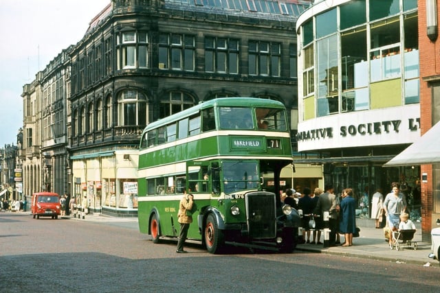 A 'West Riding' double decker Leyland bus waiting at the Wakefield bus stop outside the Morley Co-op buildings in Queen Street. The old bus stop barriers had not yet been replaced by shelters. The Co-op still occupied its 1937 (red brick) and 1957 (right of the bus) building, but its 1899 building, by the red van, had already been turned into a supermarket (Grandways then Carlines) which was competing with the Co-op itself. Somewhat later, both the Co-op and the supermarkets closed and the post-war building and Emporium became a variety of individual retail outlets, while the ground floor of the 1899 building became Barclays Bank, next door to the other banks just further down Queen Street. Pictured in July 1965.