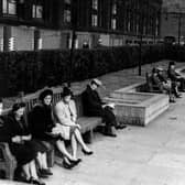 A view looking east along the Garden of Rest between the Headrow and Centenary Street, towards Cookridge Street in September 1943. Members of the public sit on the large benches in front of a hedge. Behind the hedge are the Municipal Buildings (Library, Art Gallery and Police H.Q.). Air raid protection around ground floor of Municipal Building.