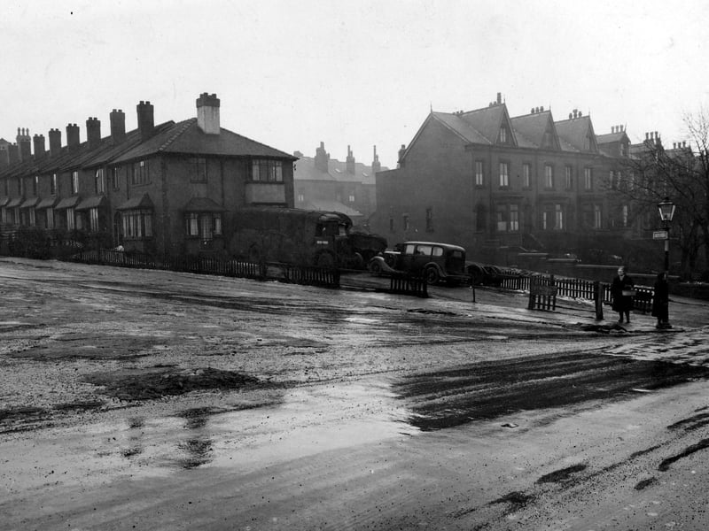 Two women waiting at a bus stop on  Burley Road at the junction with St. Michaels Lane in March 1947.
