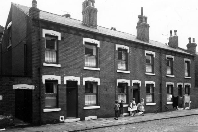 A group of young people are outside houses on Moseley Terrace in June 1963.