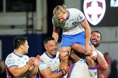 Tinirua Arona and David Fifita give Jacob Miller a lift after beating Hull KR in their final home game for Trinity. Picture by Alex Whitehead/SWpix.com.