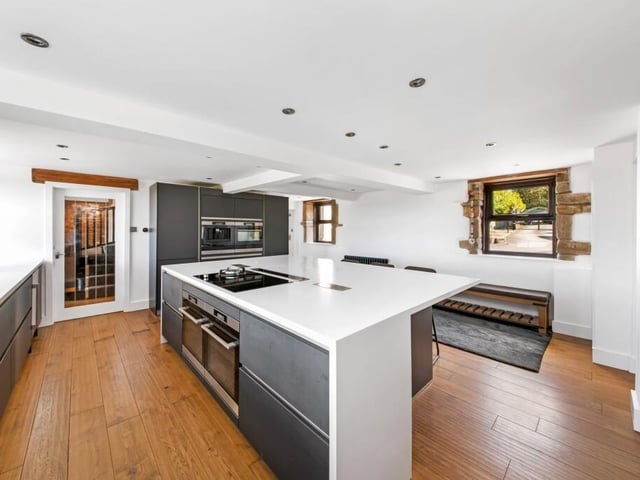 The high spec kitchen has a large island and an array of integrated appliances.