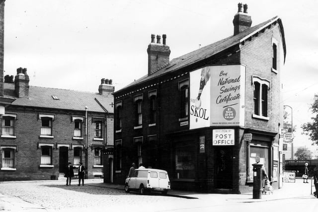 A view of Beeston Road, foreground, showing Beeston Road Post Office at number 69 on the corner with Ashfield Grove. At the rear, back-to-back terraced houses can be seen in Charmouth Terrace. A glimpse of Hunslet Hall Road can be seen far right. A sign above the Post Office advertising National Savings Certificates boasts that £1 becomes £1-5-0 in 6 years. Pictured in June 1964.