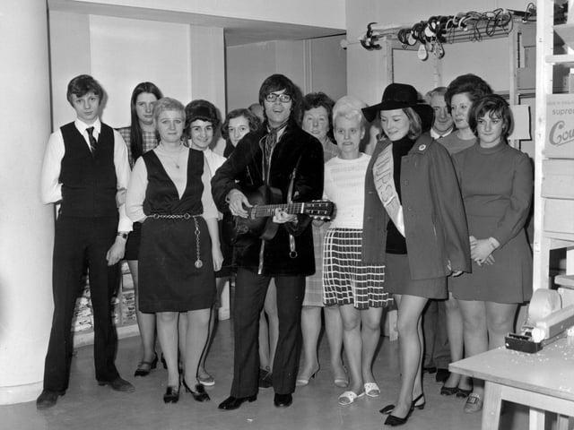 Cliff Richard is pictured at  Green Shield Stamps on Eastgate in April 1970. He is surrounded by a group of staff dressed in typical fashion of the time