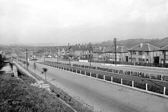 View of Selby Road after road widening. Fenced off tramlines run down centre of carriageway with wires overhead. Junction with Back Lucy Street can eb seen on right with 109 Selby Road. Property of Thomas Sleightholme (newsagents) visible on corner with next junction which is Lucy Avenue.
