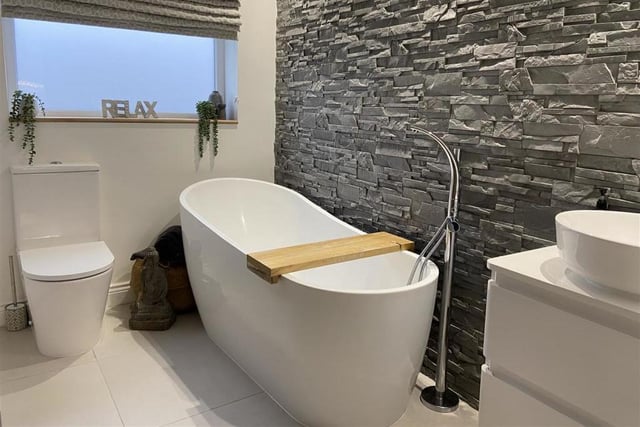 A modern bathroom with free standing bath tub.