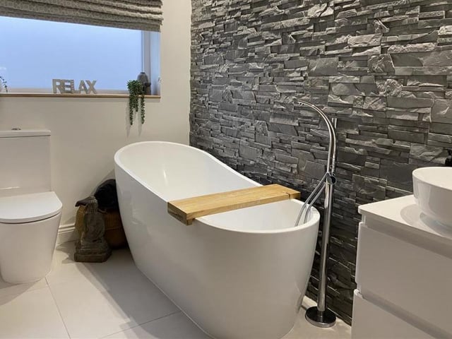 A modern bathroom with free standing bath tub.