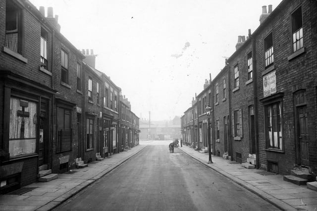 The lower end of Byron Street facing down towards the Cross with Regent Street and Millwright Street. Taken from the middle of the road, the photo shows a stepped terrace of residential houses and small shops (some disused).