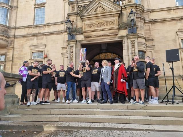 Trinity players and staff outside the town hall.