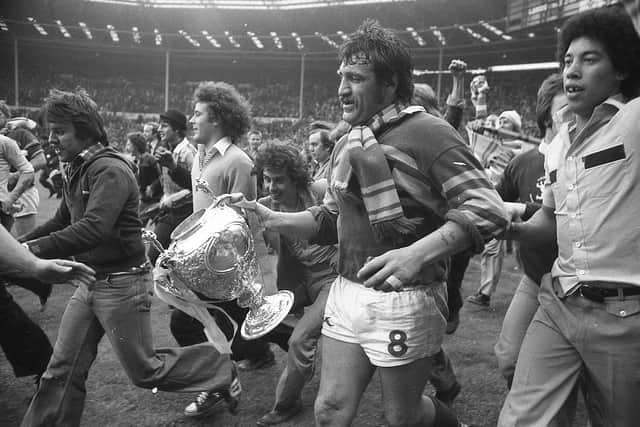 Mick Harrison, accompanied by jubilant Leeds fans, takes the Challenge Cup on a lap of honour at Wembley in 1978. Picture by Steve Riding.