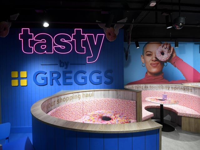The 117-seat Tasty by Greggs café is now open on the first floor of the Primark in Trinity Leeds shopping centre. The new Leeds branch features vibrant interiors and backdrops which are designed for Instagram and TikTok feeds. Customers can snap a selfie in the shop’s doughnut seating booths or on its Sausage Roll swing.