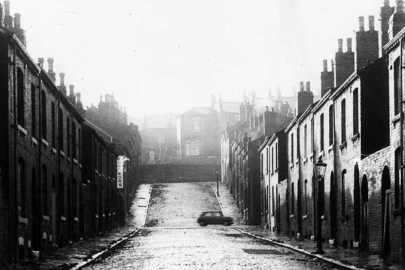 A view looking south-west along Servia Avenue from Cambridge Road towards Servia Hill in 1970. This cobbled street of terraced housing was due for demolition as part of a large clearance scheme for the area. A car is seen in the background at the point where Servia Road crosses the street.