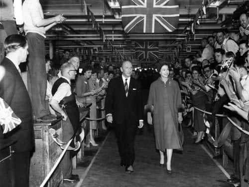 The Queenis shown around the Burton's factory in October 1958 by company chairman Lionel Jacobson. Workers applauded her on both sides with Union Jacks unfurled above.