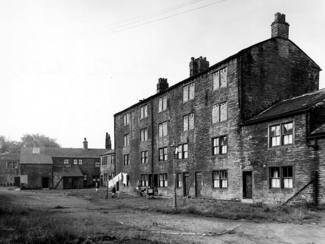 The Old Mill on Eightlands Lane pictured in August 1956 with the windows on the top two floors bricked up. Washing hanging up. Streetlamp, children, woman and prams are visible.