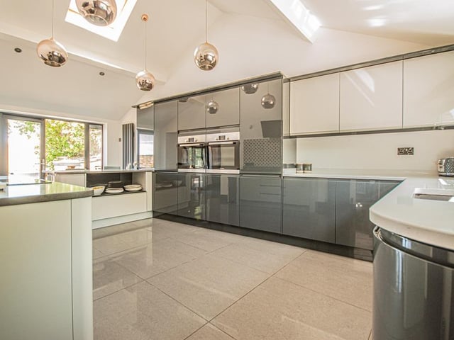 The well-lit kitchen is equipped with high spec units and appliances