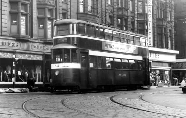 A view of Duncan Street from the junction with Lower Briggate, showing tram no.532 on route 18 to Crossgates. An advert for Heinz salad cream is seen on the side of this ex-London 'Feltham' tram. In the background are Reid Bros. Ltd., tailors, and Rawcliffe's Ltd., clothiers. Pictured in September 1957.