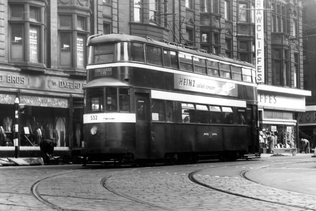 A view of Duncan Street from the junction with Lower Briggate, showing tram no.532 on route 18 to Crossgates. An advert for Heinz salad cream is seen on the side of this ex-London 'Feltham' tram. In the background are Reid Bros. Ltd., tailors, and Rawcliffe's Ltd., clothiers. Pictured in September 1957.