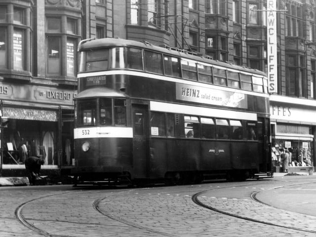 A view of Duncan Street from the junction with Lower Briggate, showing tram no.532 on route 18 to Crossgates. An advert for Heinz salad cream is seen on the side of this ex-London 'Feltham' tram. In the background are Reid Bros. Ltd., tailors, and Rawcliffe's Ltd., clothiers. Pictured in September 1957.