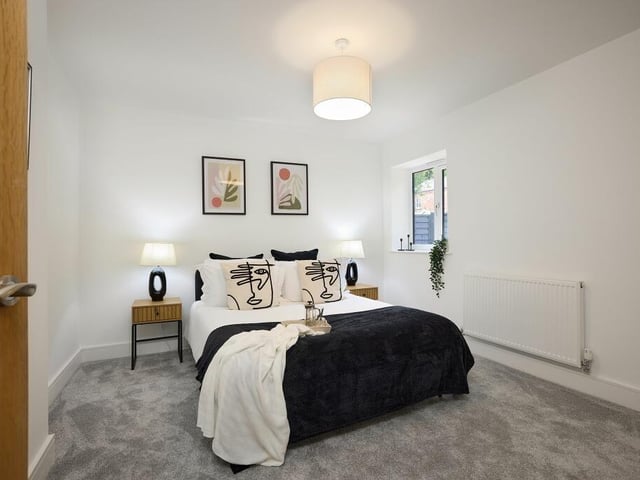The first of the bedrooms is carpeted in plush grey, with a private ensuite.
