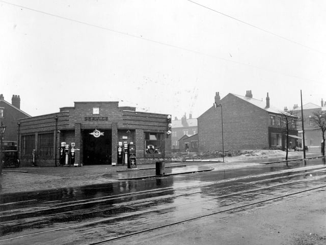Chapeltown Road from Cowper Street, looking at Savile Service station and garage Art Deco building, petrol pumps, signs, and vehicles can be seen. Pictured in April 1935.
