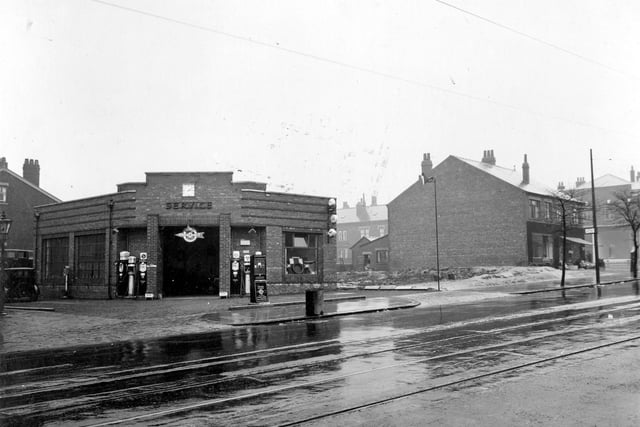 Chapeltown Road from Cowper Street, looking at Savile Service station and garage Art Deco building, petrol pumps, signs, and vehicles can be seen. Pictured in April 1935.