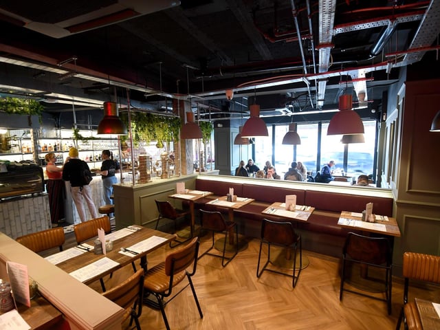 The venue's decor brings in exposed brick, neon signs and lush plants