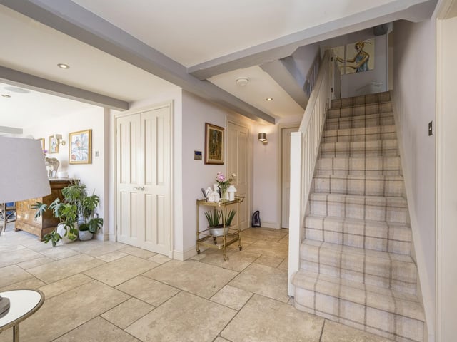 The beamed entrance hallway is spacious, with a staircase leading up.