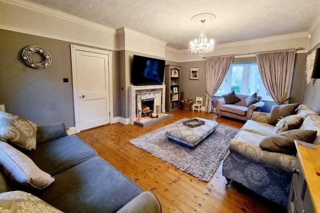 A spacious lounge with feature fireplace and bay window.