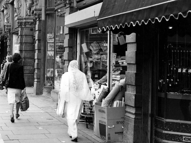 Shoppers on Vicar Lane in May 1984. Kirkgate Market Buildings are on the right. Joseph Hemsworth, jeweller, is in the foreground, then Economic Woollen Company, fabrics, and Cut Price Records.