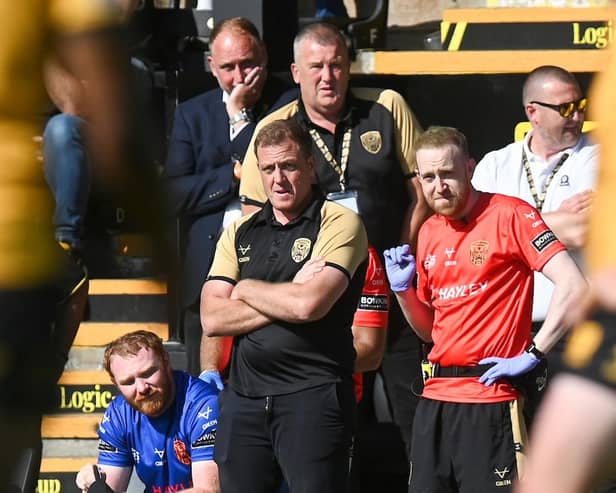Ryan Carr, front with arms folded, watches from pitchside during the second half of Castleford Tigers' win against Leeds Rhinos in July. Picture by Matthew Merrick/SWpix.com.