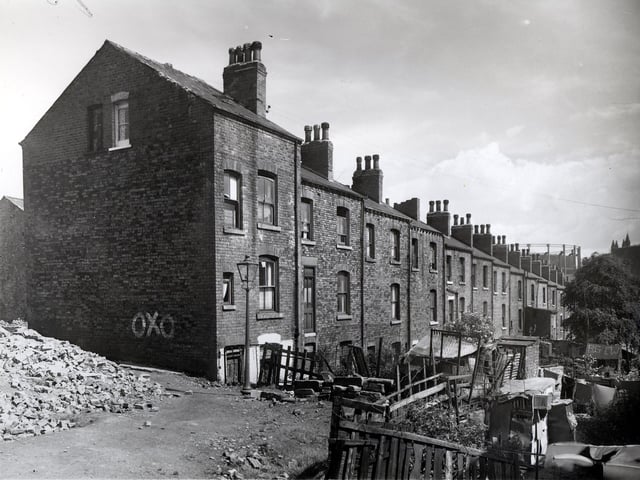 This is looking from Camp Road in the direction of Meanwood Road along Back Glover Street in July 1958. The houses in view fronted onto Glover Street. Towards the right above the houses, the top of a gasometer can be seen. This was situated off Barrack Street, Sheepscar.