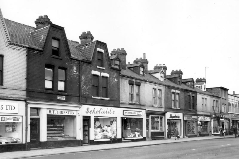 Shops pictured in March 1966. H.T. Thurston, bakers and confectioners. Other businesses are Schofield's drapers, Doreen Hammonds hair fashions, William Pound, butcher and Hagenbachs continental bakers. A branch of Woolworths can be seen on the right edge and possibly stands on the site of the Embasy cinema which closed in 1956