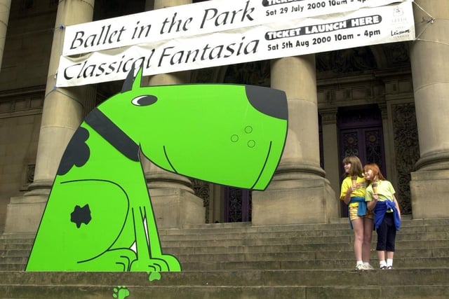 Emma Lowde (left) and sister Sophie from Walton near Wetherby, meet Geoffrey, the 12 foot green dog who was the mascot of Leeds Leisure Services, while queuing for the first tickets for the free Classical Fantasia tickets in 2000.