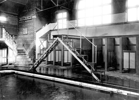 Holbeck Baths pictured in September 1926. Located on Holbeck Lane, the baths were opened in 1898 and closed in 1979. This view shows the swimming pool with diving platform. To the left, steps leading to a spectators balcony with changing cubicles underneath. More cubicles can be seen behind the diving board.