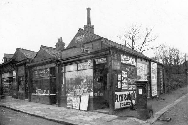 Meanwood Post Office at junction of Stonegate Road and Authorpe Road in January 1937. There are billboards with headlines from the Leeds Mercury and Yorkshire Post Newspapers and a sign for the circulating library and public telephone. On the corner is a letter box. Next door is Leeds Drug Co. dispensing Chemist, and The Public Benefit Boot Co