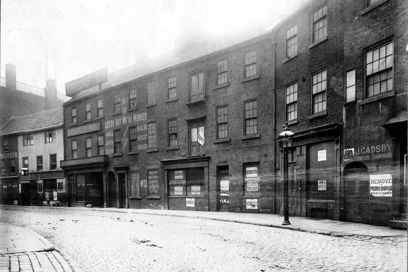 The south side of Swinegate in August 1904 immediately before demolition for street improvements. From left to right is Marks Liberson, Cabinet maker; Ye Olde Dustye Miller Inn; Beechcroft, clothiers' engineers; Thomas Waite, Leeds Art Metal Worker; Wallis and Watson, electrical engineers; British United Shoe Machinery Co. Ltd.; J.W. Gadsby, perambulator manufacturer and furniture showroom. All these premises are vacant.