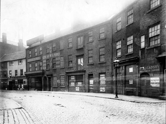 The south side of Swinegate in August 1904 immediately before demolition for street improvements. From left to right is Marks Liberson, Cabinet maker; Ye Olde Dustye Miller Inn; Beechcroft, clothiers' engineers; Thomas Waite, Leeds Art Metal Worker; Wallis and Watson, electrical engineers; British United Shoe Machinery Co. Ltd.; J.W. Gadsby, perambulator manufacturer and furniture showroom. All these premises are vacant.