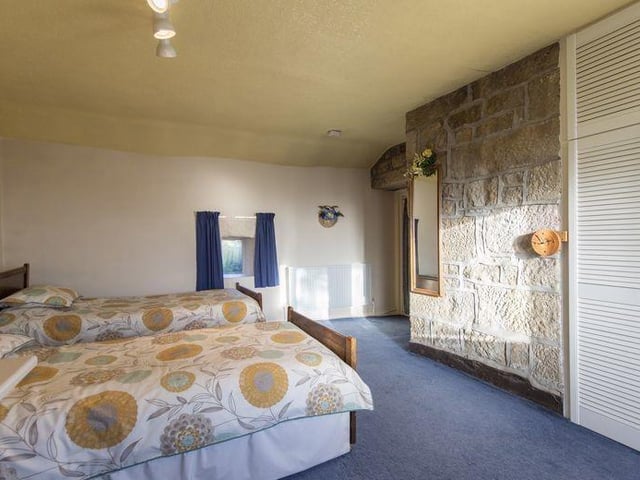 Bedrooms are spacious - this one has a feature exposed stone wall.