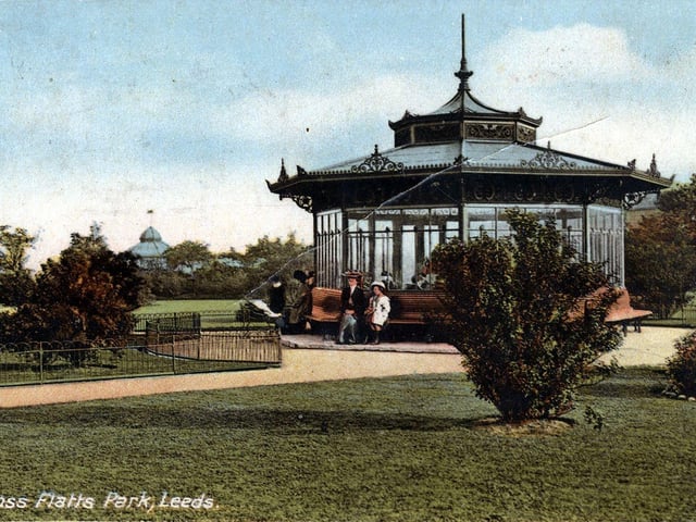A colour-tinted postcard of Cross Flatts Park with a postmark of May 11, 1913. An octagonal shelter has seating around the outside. The bandstand is just seen in the background.